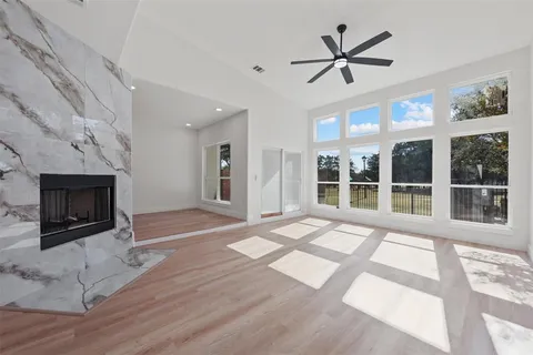 a view of an empty room with a fireplace and wooden floor