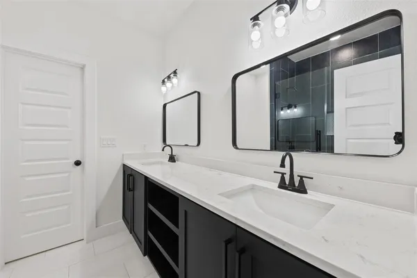 a bathroom with a double vanity sink and mirror
