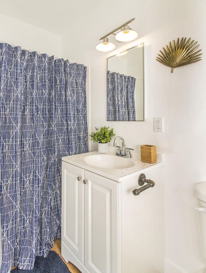 68080 Risueno Road Cathedral City, CA 92234 - Photo 72 of 98 a bathroom with a sink a mirror and a shower curtain