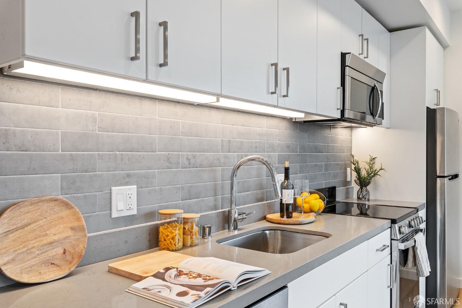 1201 Sutter Street, Unit PH603 San Francisco, CA 94109 - Photo 3 of 13 a kitchen with stainless steel appliances granite countertop a sink and white cabinets