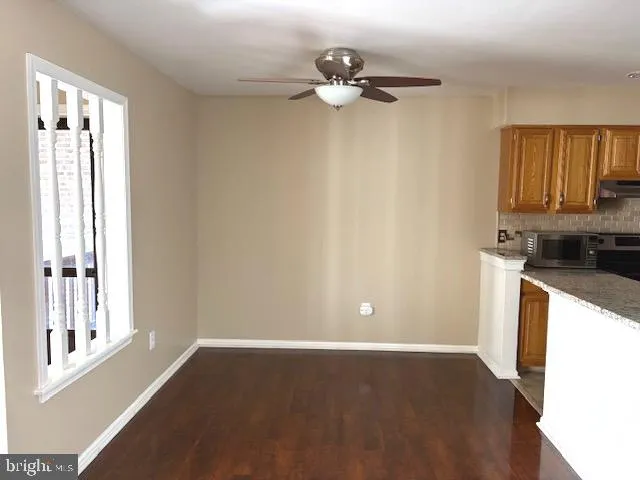 a view of a kitchen with wooden floor and a window