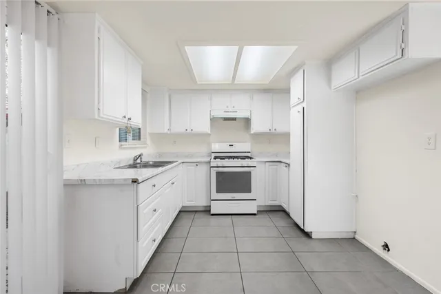 a kitchen with a stove sink and cabinets