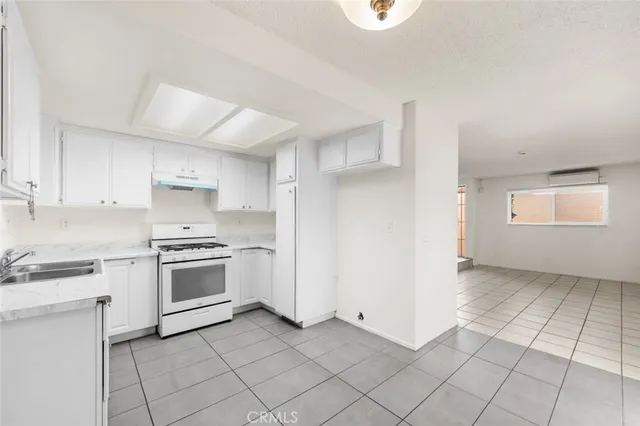 a kitchen with granite countertop white cabinets and appliances