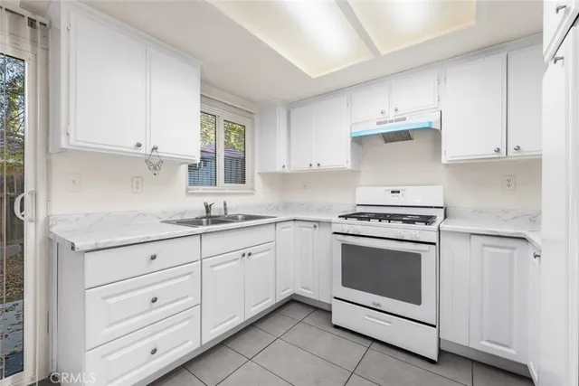 a kitchen with granite countertop white cabinets and white appliances