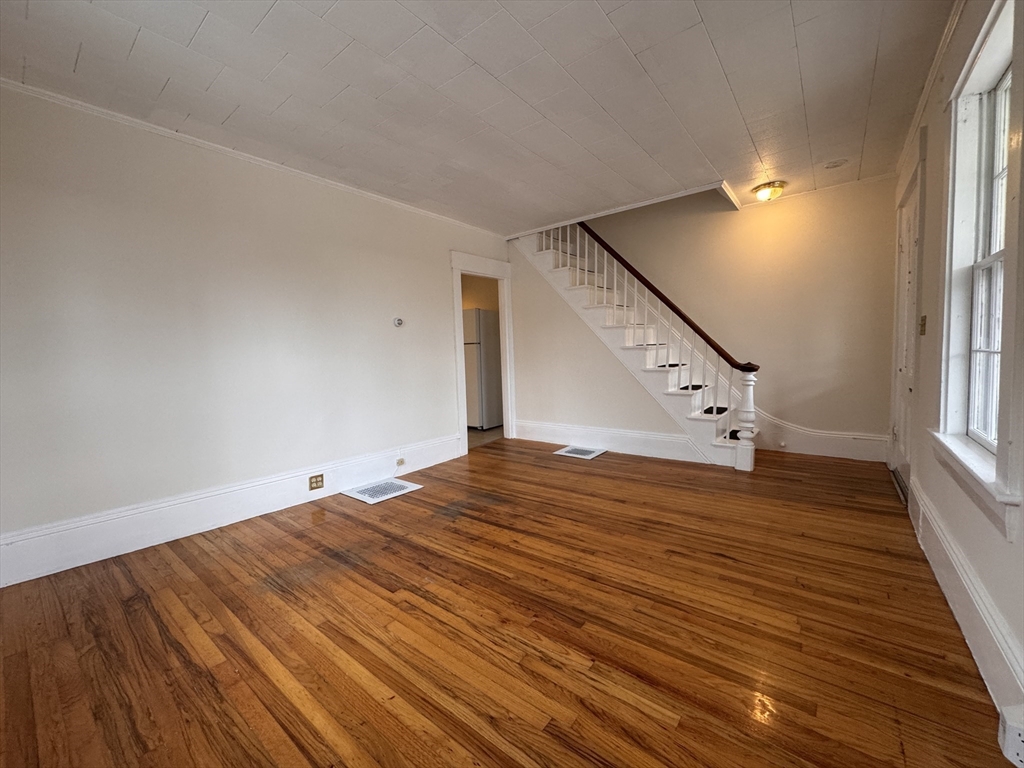 a view of empty room with wooden floor
