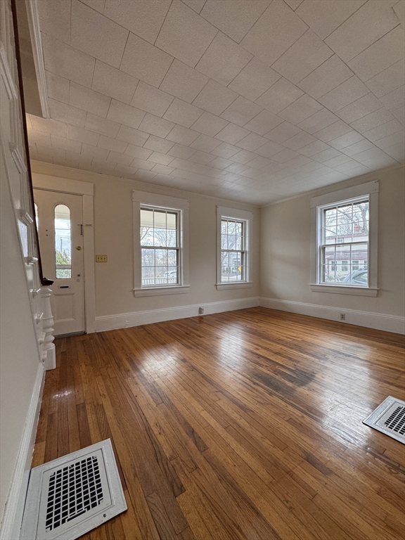 68 Cottage Street, Unit 68 Newton, MA 02464 - Photo 3 of 16 an empty room with wooden floor and windows