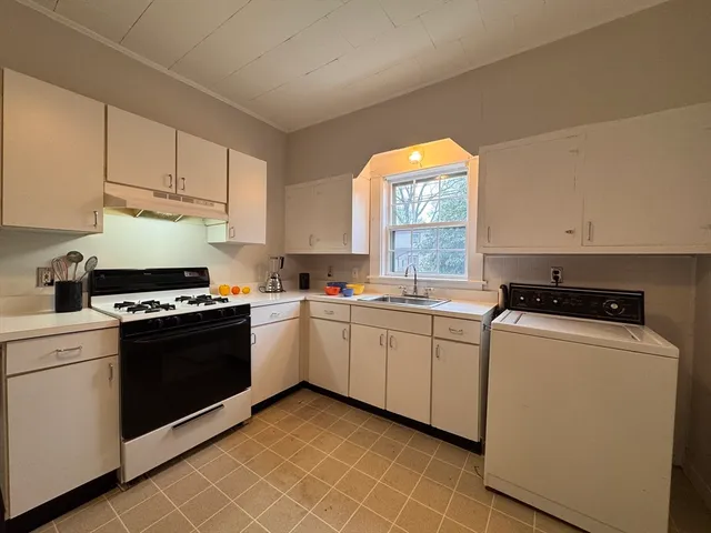a kitchen with cabinets appliances and a window
