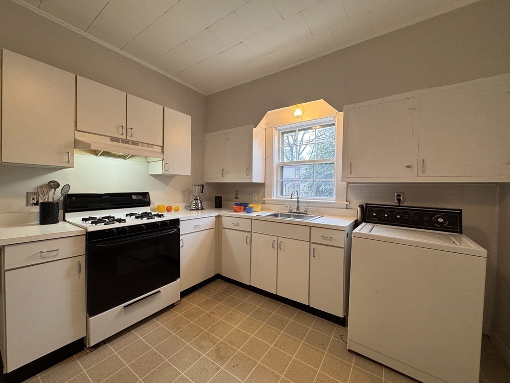 68 Cottage Street, Unit 68 Newton, MA 02464 - Photo 8 of 16 a kitchen with cabinets appliances and a window