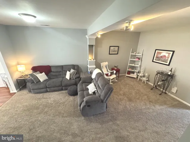 a view of a hallway with wooden floor and furniture