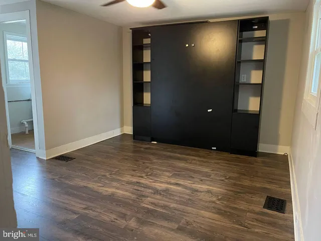 an empty room with wooden floor and closet