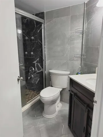 a bathroom with a shower toilet and sink