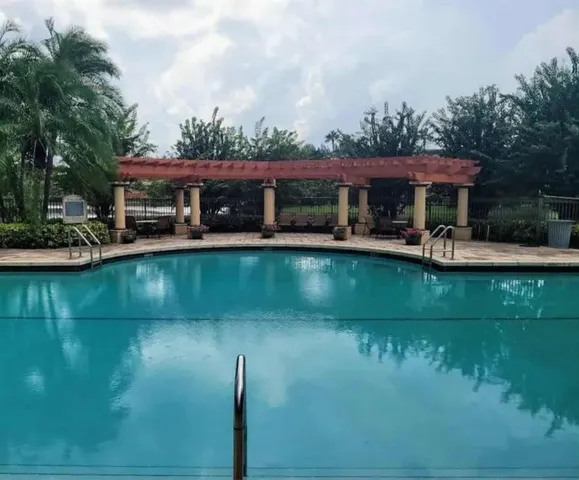 a view of a lake with a table and chairs under an umbrella