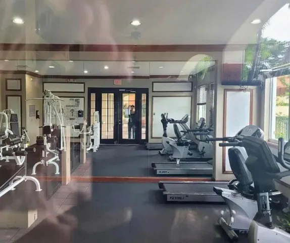 a room with gym equipment and large mirror