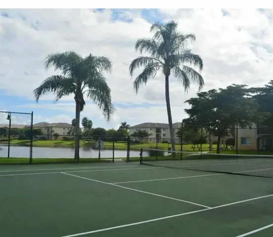 a view of a tennis court with palm trees