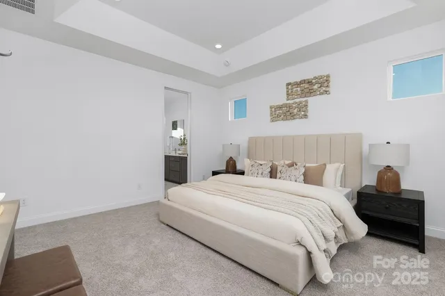 a bedroom with a bed and a lamp on dresser