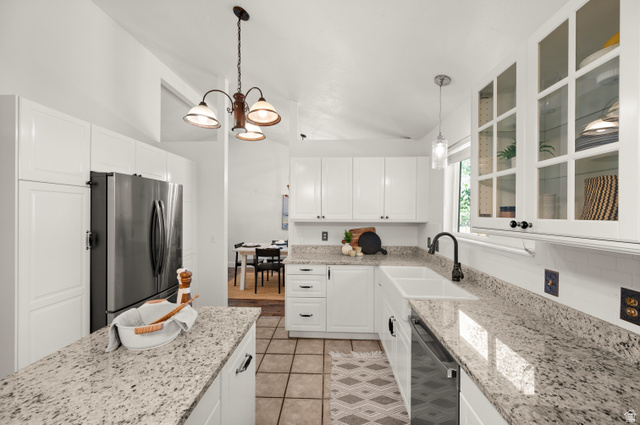 2163 Borg Drive Sandy, UT 84092 - Photo 7 of 31 Kitchen featuring light stone counters, stainless steel appliances, white cabinetry, glass insert cabinets, and vaulted ceiling