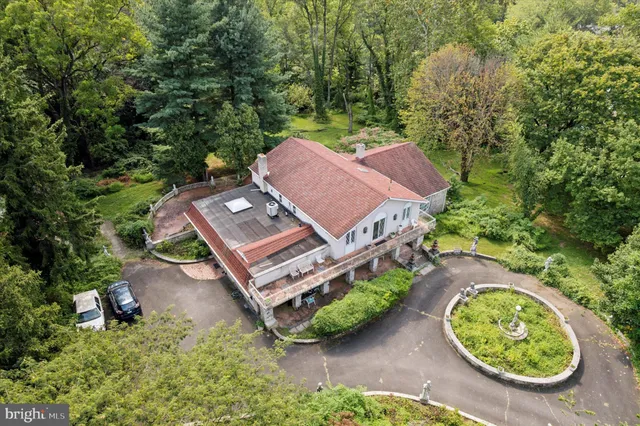 an aerial view of a house with garden space and a swimming pool