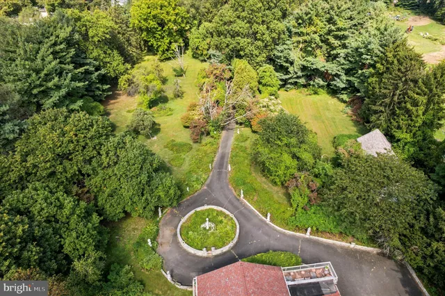 an aerial view of a house with a yard and green space