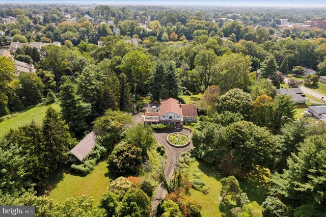 an aerial view of a house with a yard and large trees