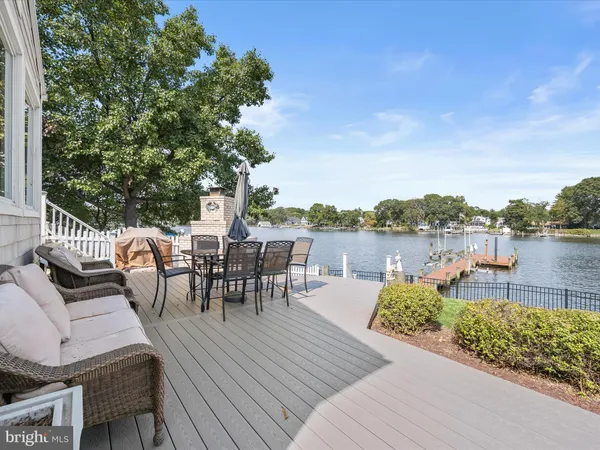 a view of a patio with couches and a dining table and chairs with wooden floor