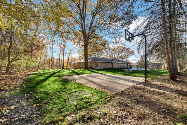 a view of a house with a big yard and large trees