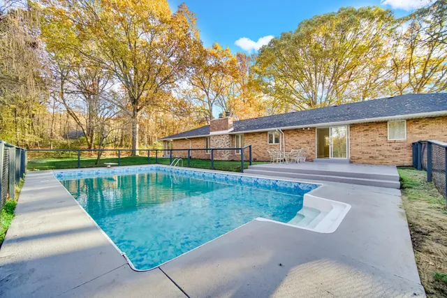 a view of house with swimming pool and sitting area