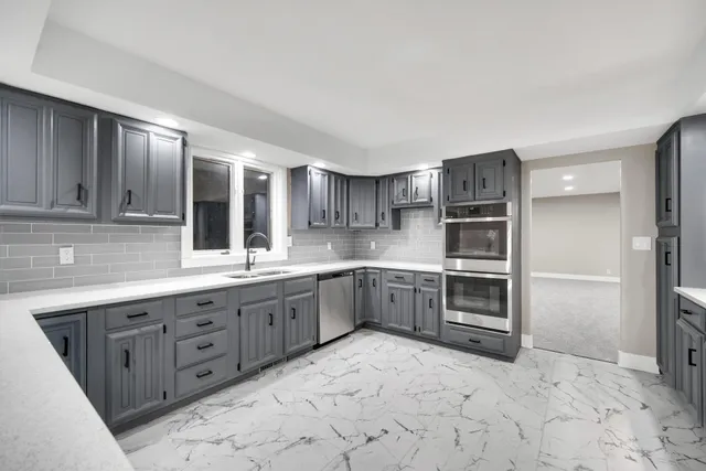 a kitchen with stainless steel appliances a sink and a refrigerator