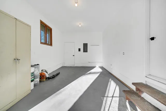 a view of a room that has a bed and wooden floor