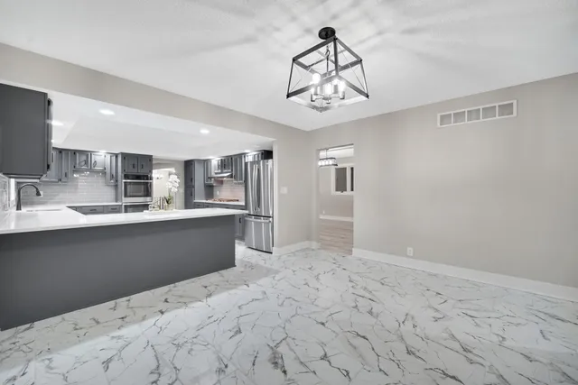 a kitchen with stainless steel appliances a refrigerator and microwave