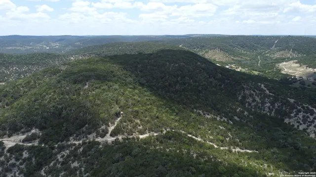 a view of a mountain range with lush green forest