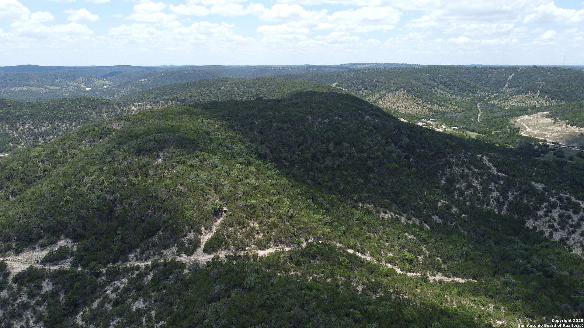 a view of a mountain range with lush green forest