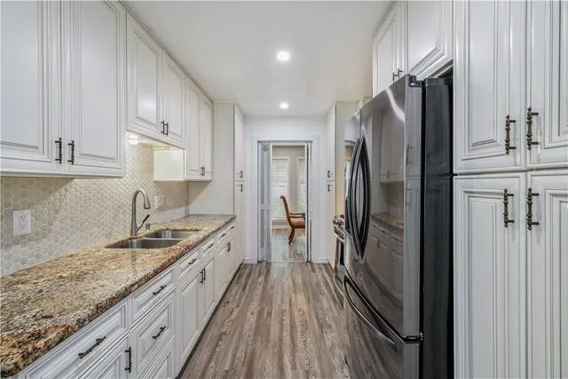 a kitchen with stainless steel appliances granite countertop a refrigerator and a sink
