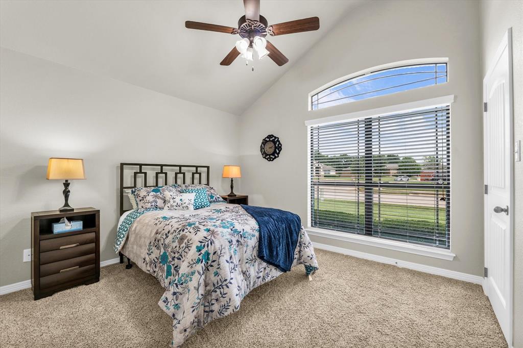 814 Springdale Circle Lorena, TX 76655 - Photo 17 of 37 Carpeted room featuring a vaulted ceiling with a ceiling fan, a large window with blinds, and an arched transom window