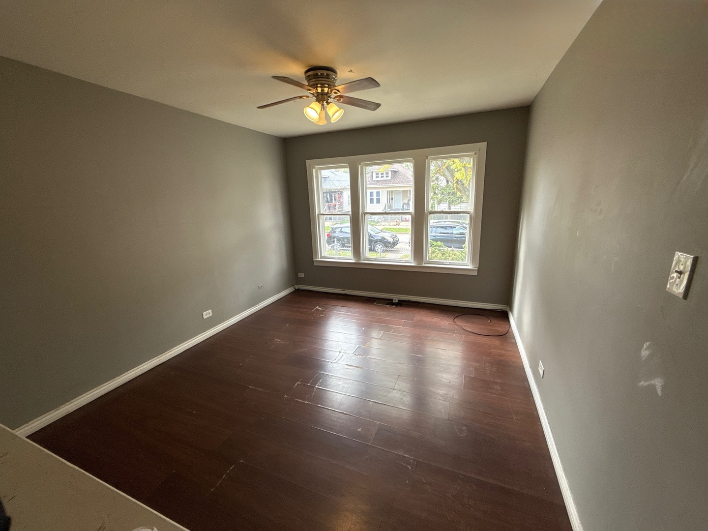 10721 South Prairie Avenue Chicago, IL 60628 - Photo 4 of 14 an empty room with wooden floor and windows