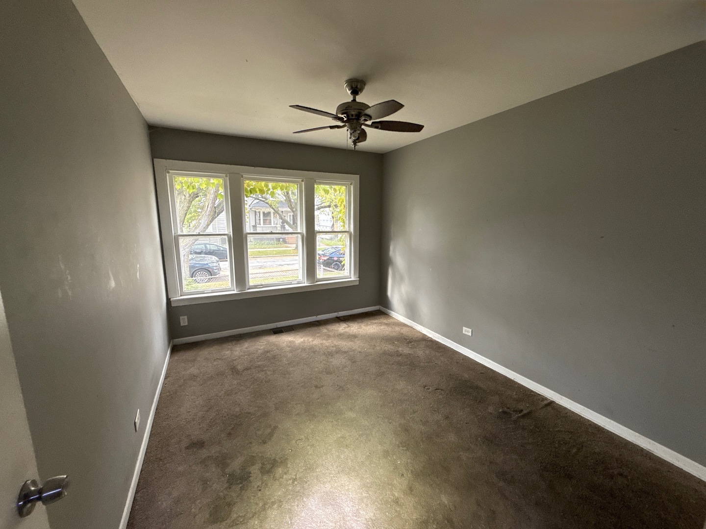 10721 South Prairie Avenue Chicago, IL 60628 - Photo 6 of 14 an empty room with a window and a ceiling fan