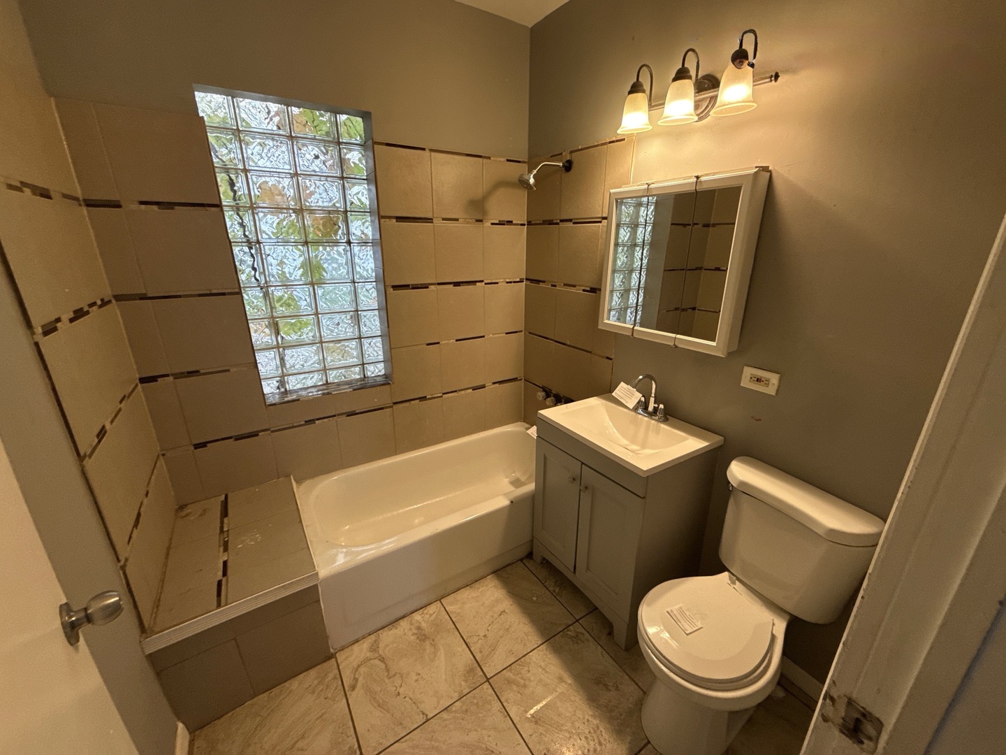 10721 South Prairie Avenue Chicago, IL 60628 - Photo 7 of 14 a bathroom with a sink toilet and shower