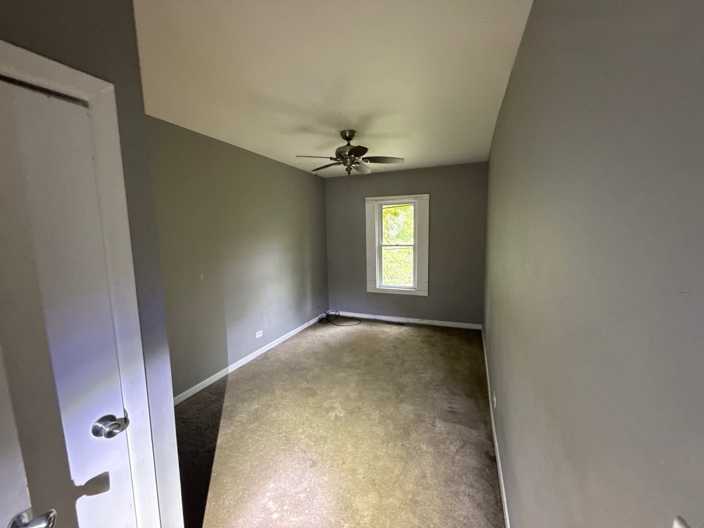 10721 South Prairie Avenue Chicago, IL 60628 - Photo 8 of 14 an empty room with windows and a ceiling fan