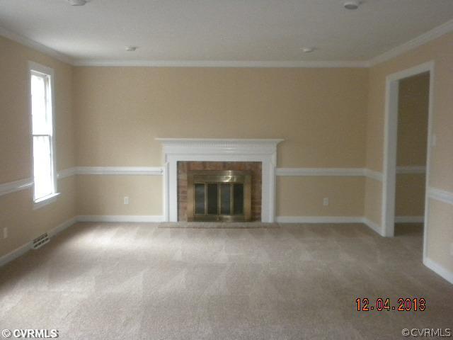 13750 Elmstead Road Midlothian, VA 23113 - Photo 4 of 9 an empty room with a fireplace and windows