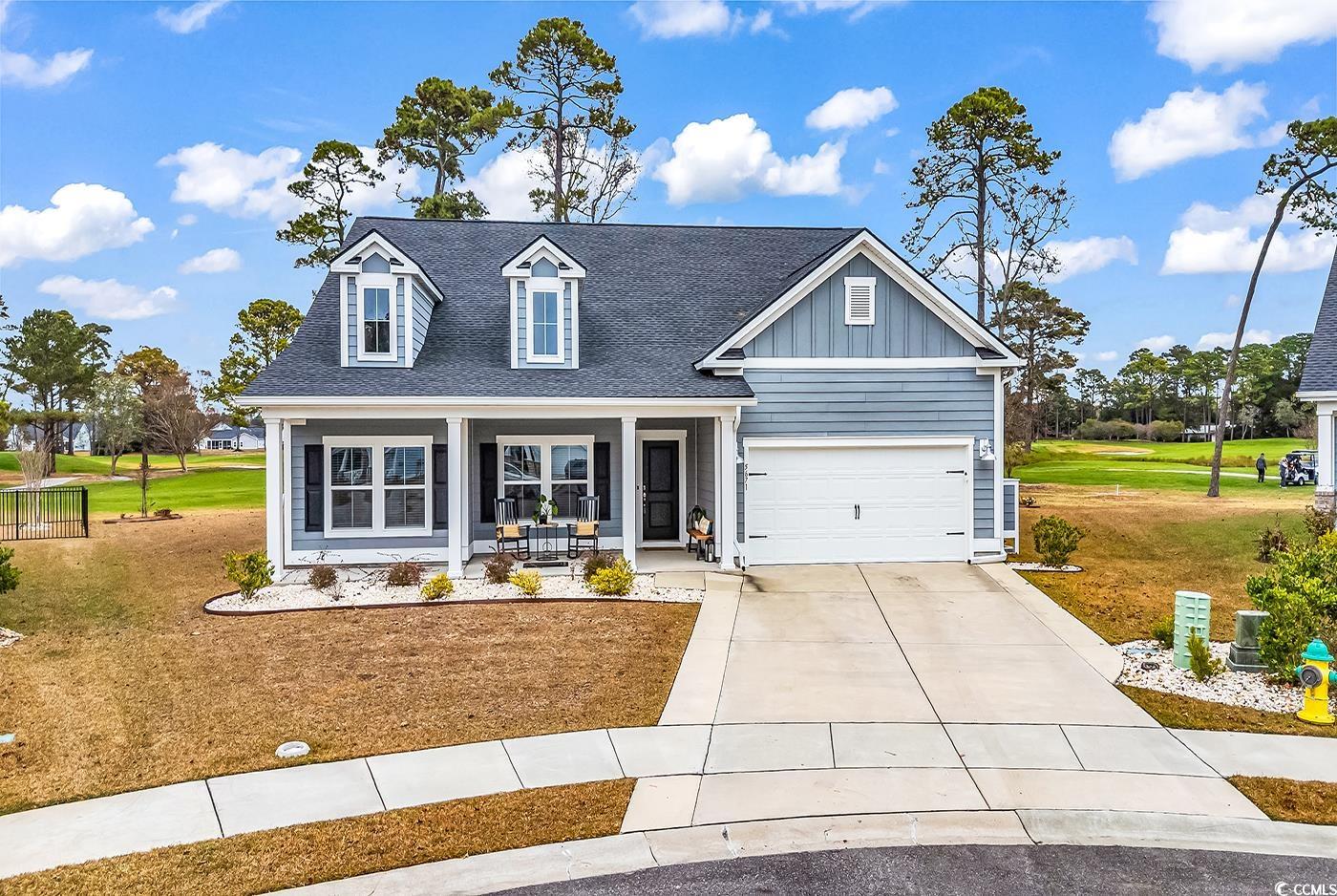 View of front of house with board and batten siding, a porch, a front yard, and a shingled roof