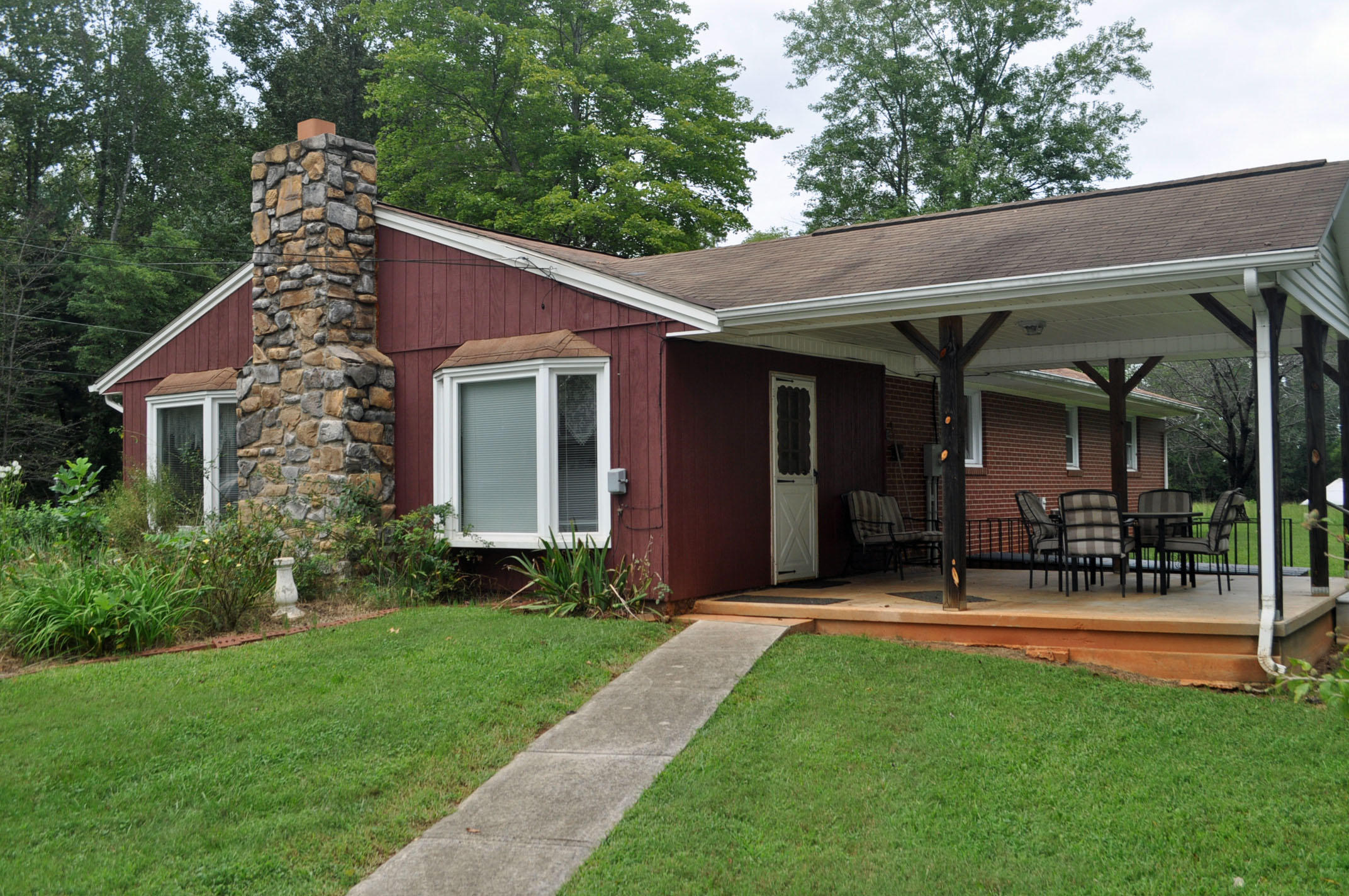 124 Pony Ridge Road Bassett, VA 24055 - Photo 15 of 41 a view of a house with small yard plants and a large tree