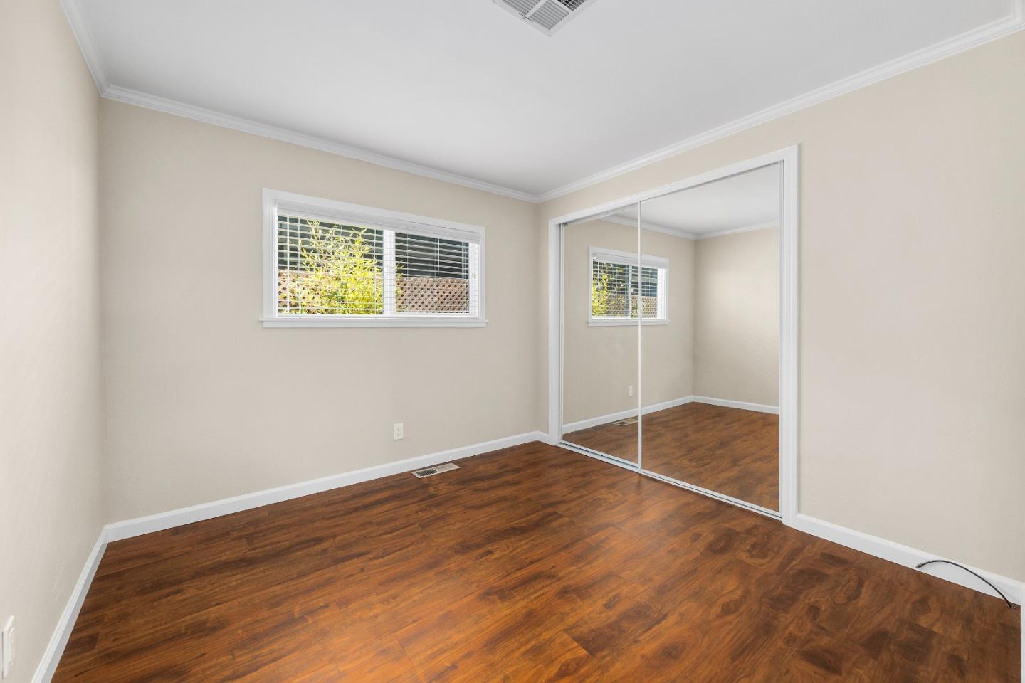 4160 Jade Street, Unit 69 Capitola, CA 95010 - Photo 14 of 27 an empty room with wooden floor and windows