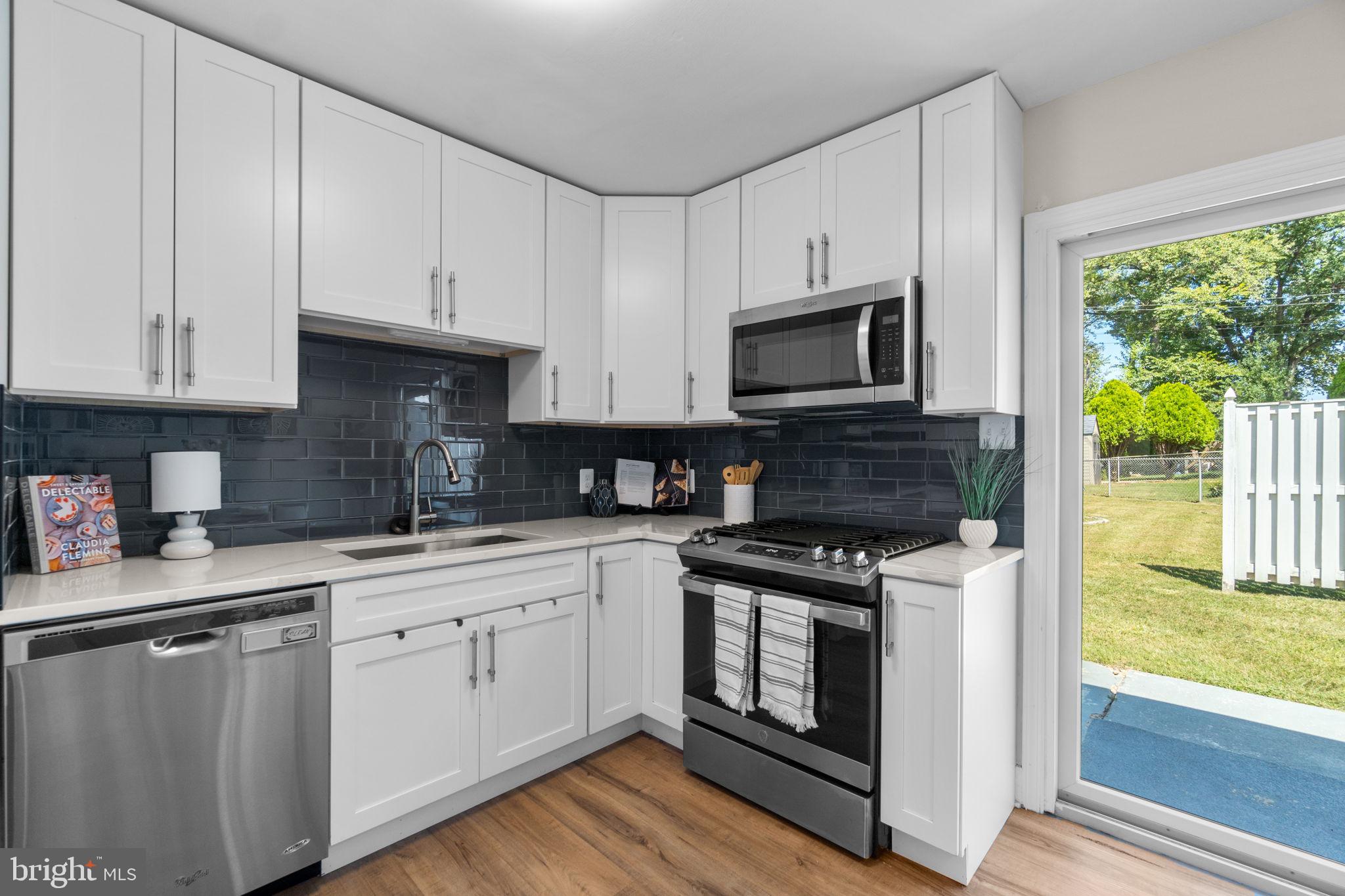 1012 Dunholme Road Reisterstown, MD 21136 - Photo 11 of 30 a kitchen with stainless steel appliances granite countertop a stove a sink and white cabinets