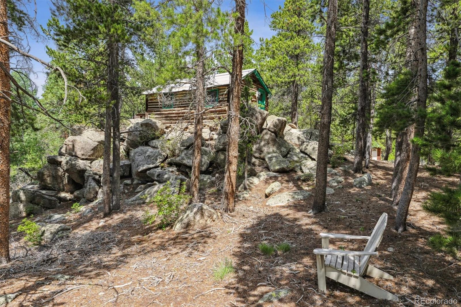 306 Olde Carter Lake Road Golden, CO 80403 - Photo 12 of 24 a backyard of a house with table and chairs