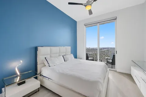 a bedroom with a bed a table and painting on the wall