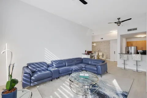 a living room with furniture and a view of kitchen