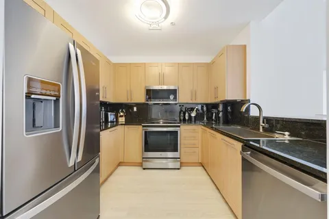 a kitchen with granite countertop stainless steel appliances and white cabinets