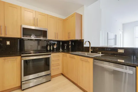 a kitchen with stainless steel appliances granite countertop a stove microwave and sink