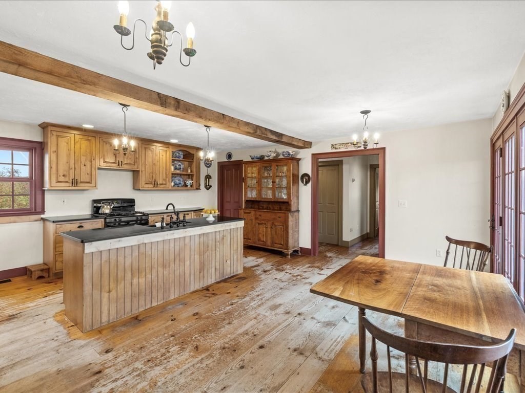 439 Lower Road Hardwick, MA 01031 - Photo 7 of 41 a kitchen with stainless steel appliances kitchen island granite countertop a table chairs in it and wooden floors