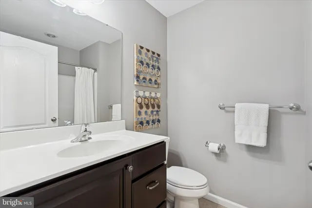 a bathroom with a sink a toilet and a large mirror