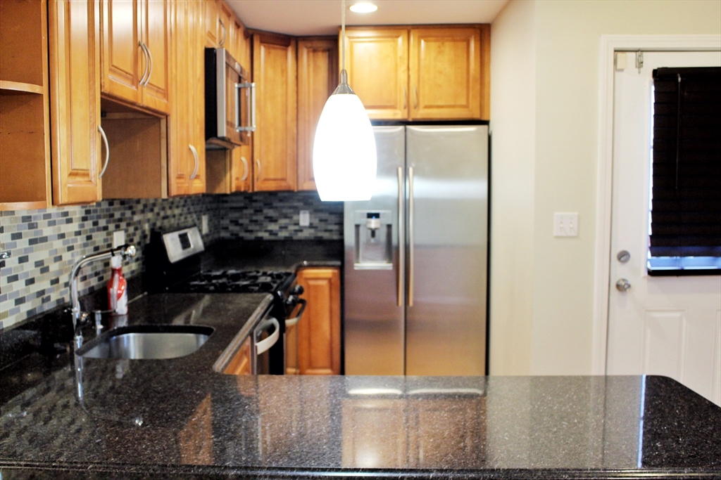 88-90 George Street Boston, MA 02119 - Photo 7 of 15 a kitchen with a refrigerator and a stove top oven